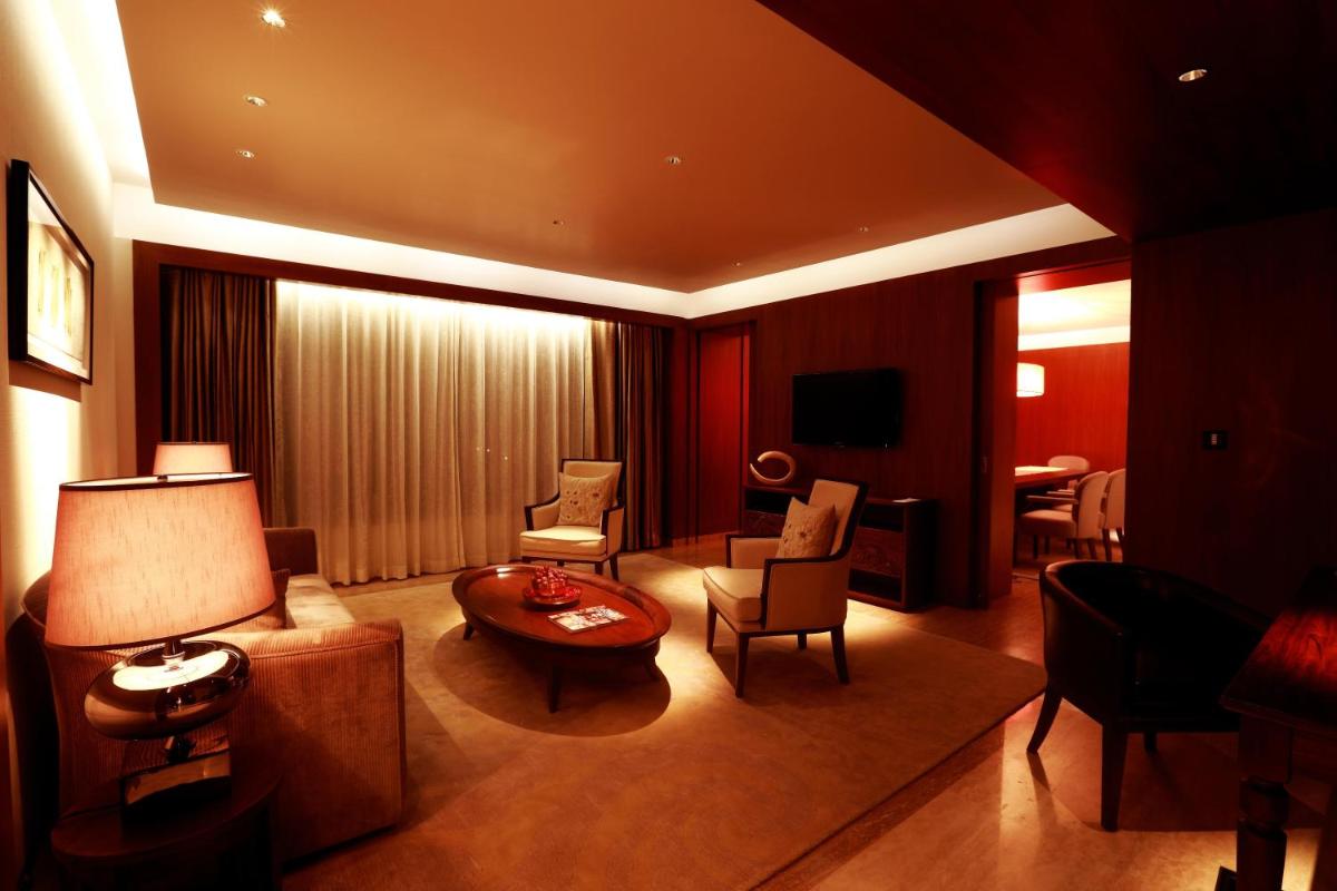 a living room with a couch and a table and chairs at Park Hyatt Chennai in Chennai