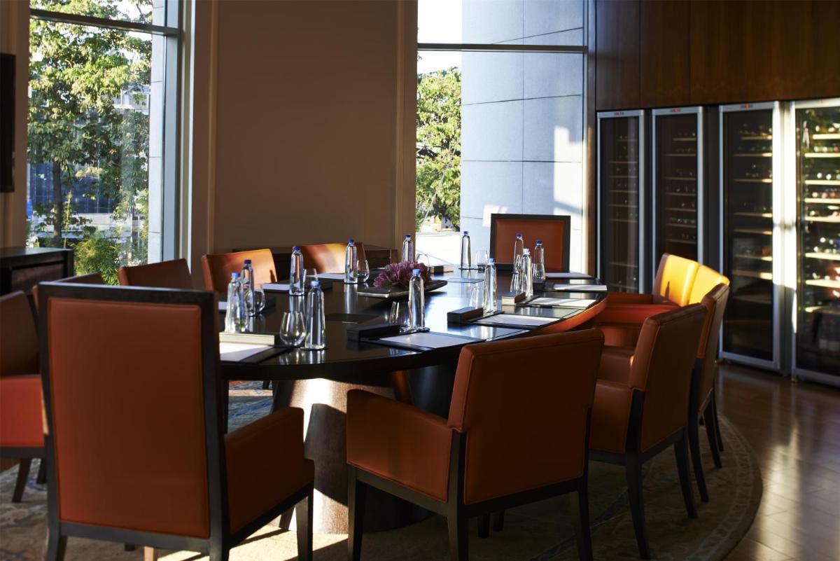 a dining room with a long table and chairs at Park Hyatt Chennai in Chennai
