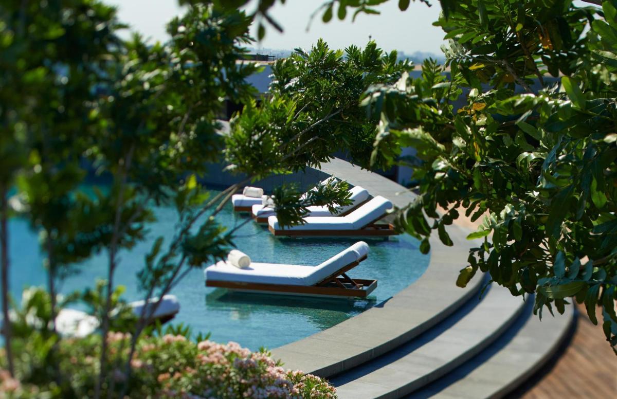 a row of lounge chairs in the water at a resort at Park Hyatt Chennai in Chennai