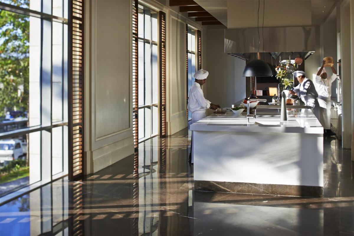 a kitchen with two chefs preparing food in a room at Park Hyatt Chennai in Chennai