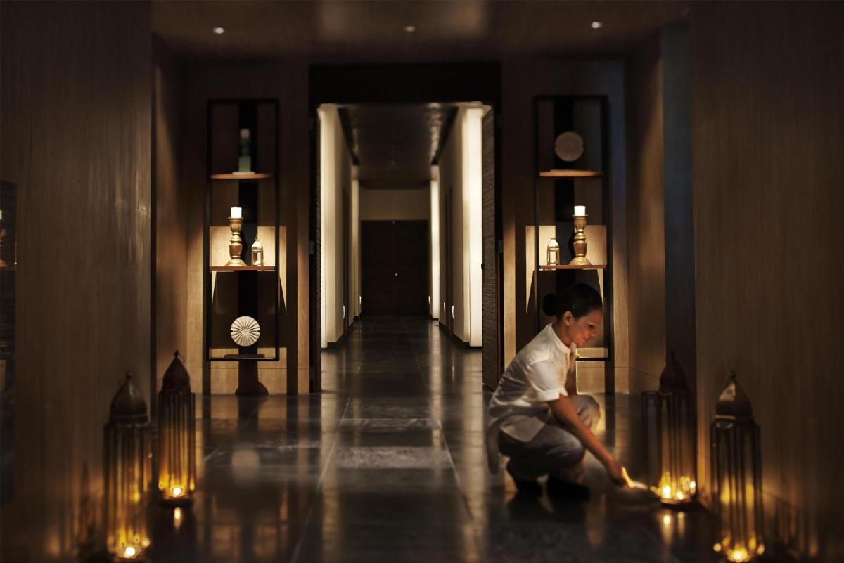 a man kneeling on the floor in a hallway with lights at Park Hyatt Chennai in Chennai