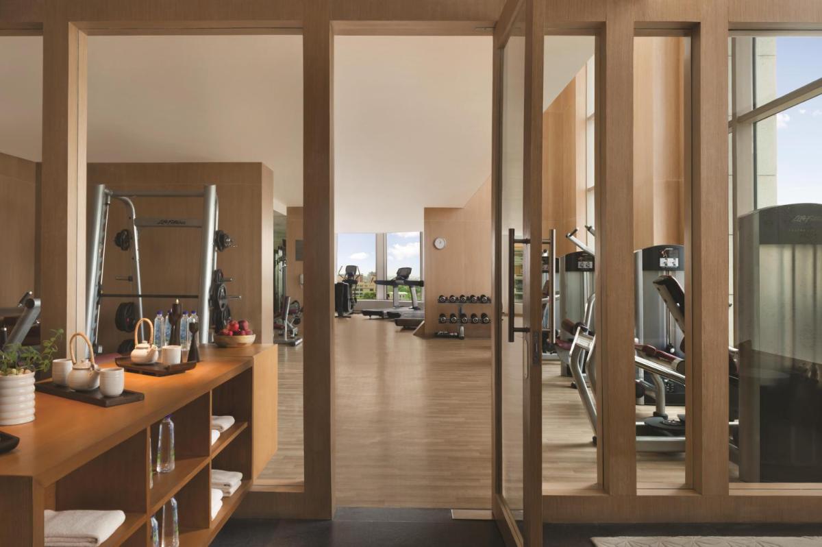 a gym with treadmills and elliptical machines at Park Hyatt Chennai in Chennai