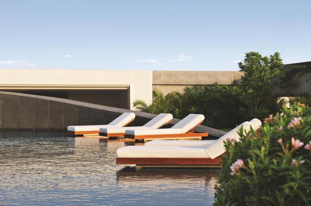 a row of lounge chairs sitting on top of water at Park Hyatt Chennai in Chennai