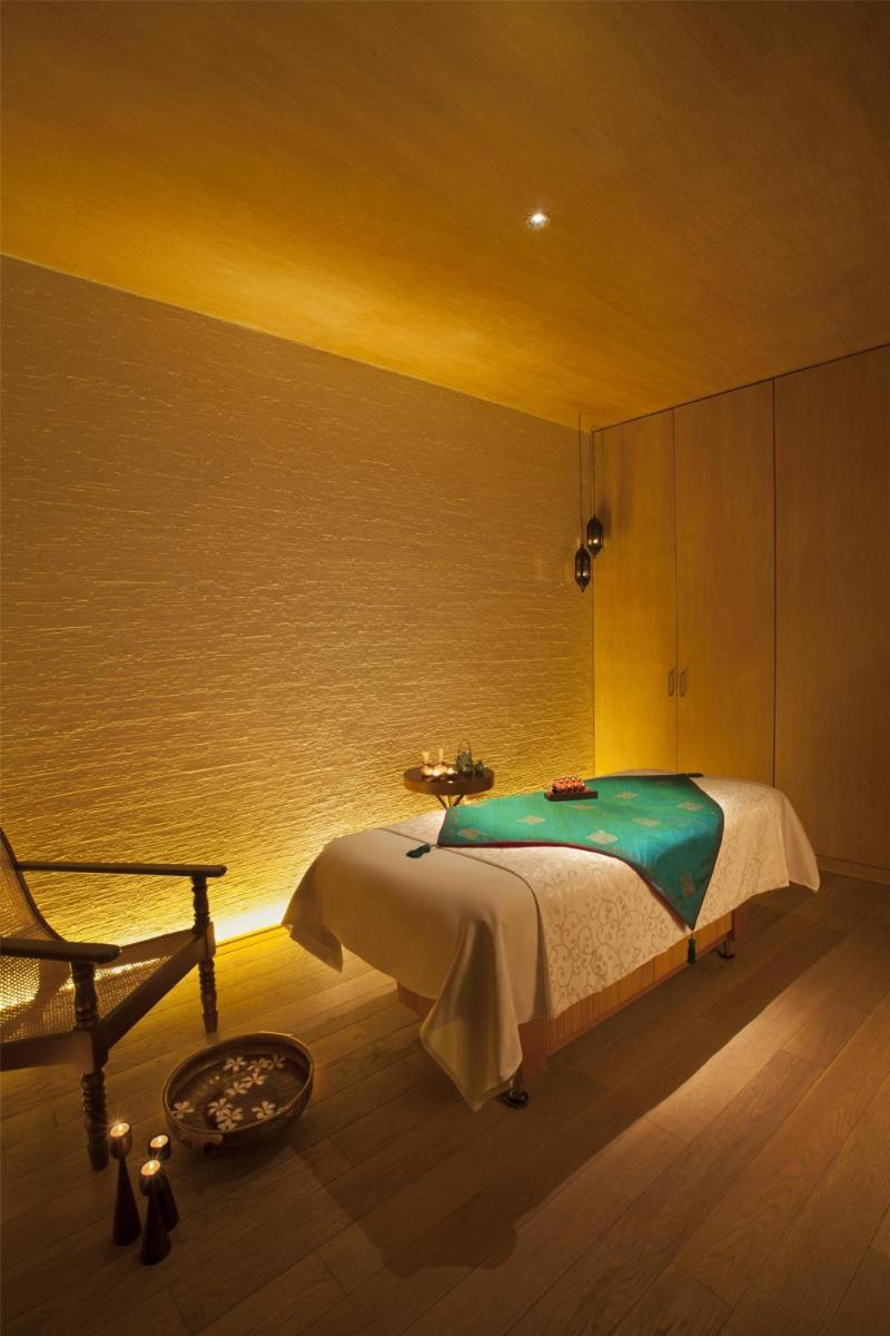 a bedroom with a bed and a chair in a room at Park Hyatt Chennai in Chennai