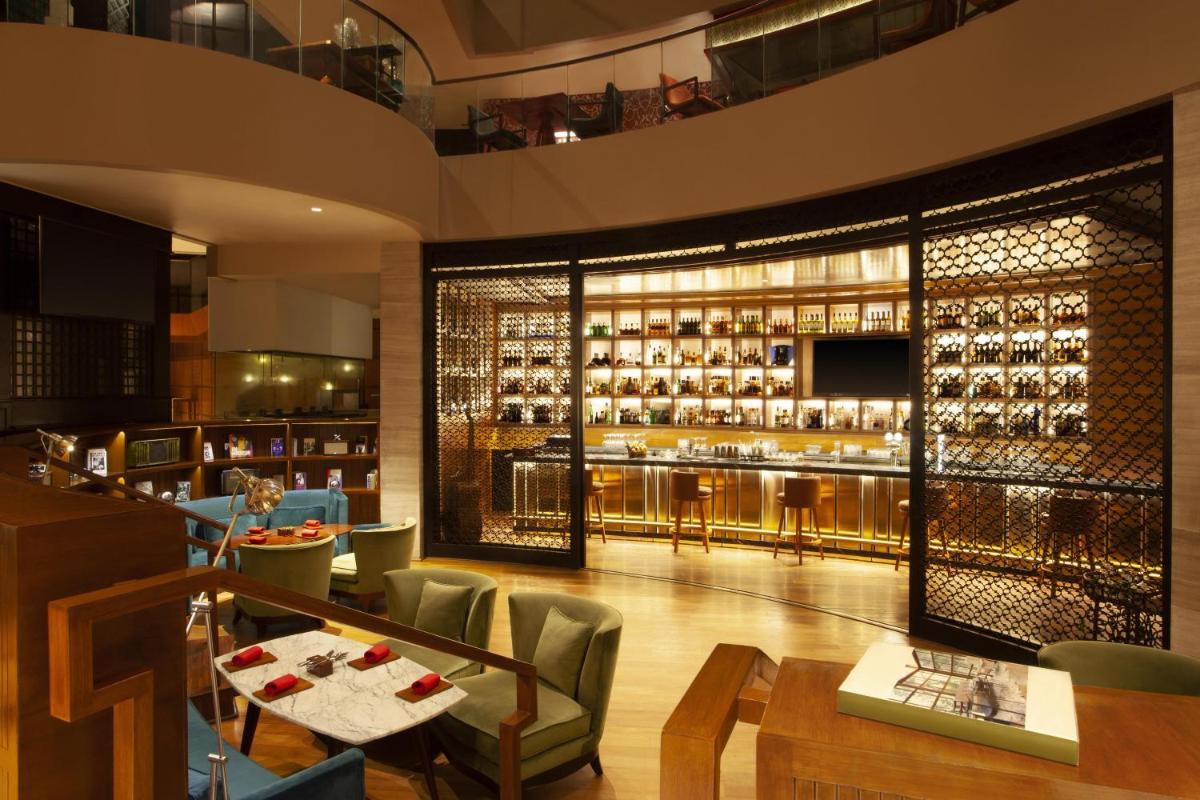 a restaurant with a bar with a lot of wine bottles at Park Hyatt Chennai in Chennai