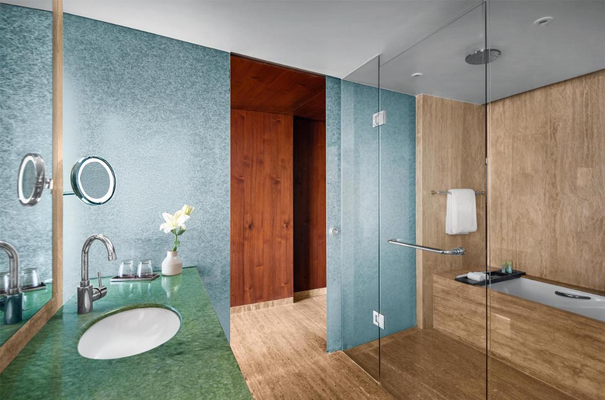 a bathroom with a sink and a glass shower at Park Hyatt Chennai in Chennai