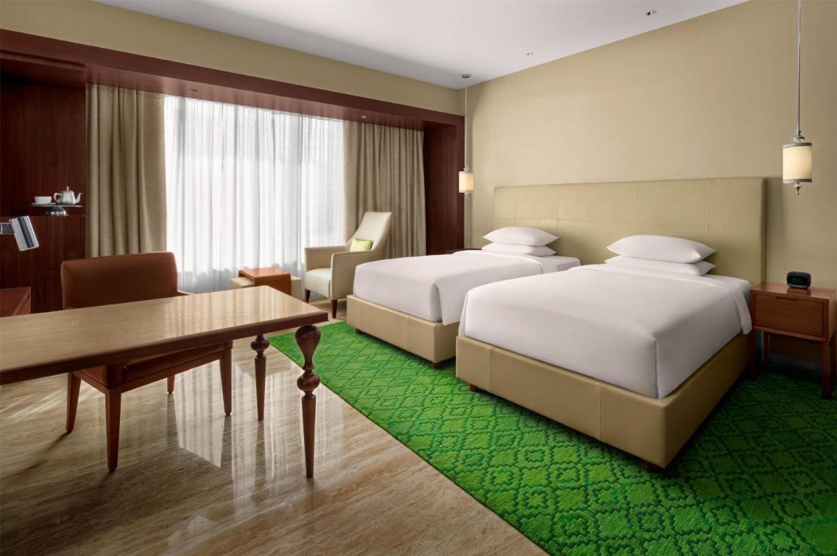 a hotel room with two beds and a table at Park Hyatt Chennai in Chennai
