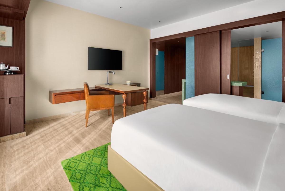 a hotel room with a bed and a desk at Park Hyatt Chennai in Chennai