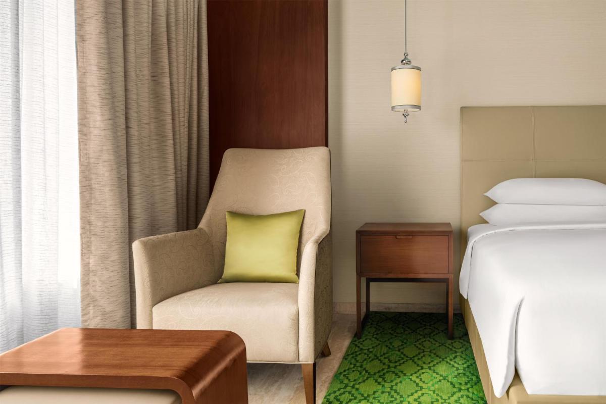 a hotel room with a chair and a bed at Park Hyatt Chennai in Chennai