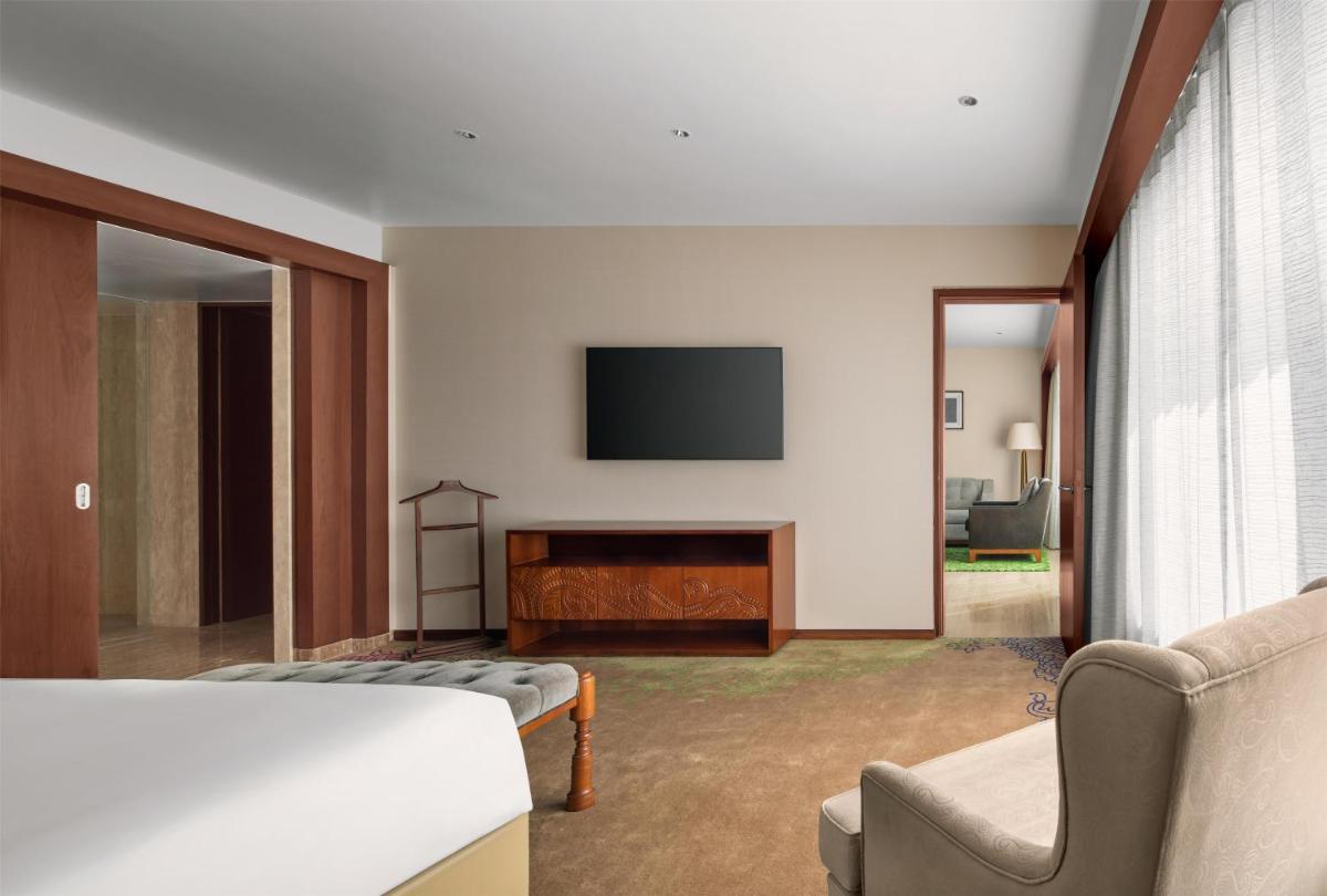 a living room with a flat screen tv on a wall at Park Hyatt Chennai in Chennai