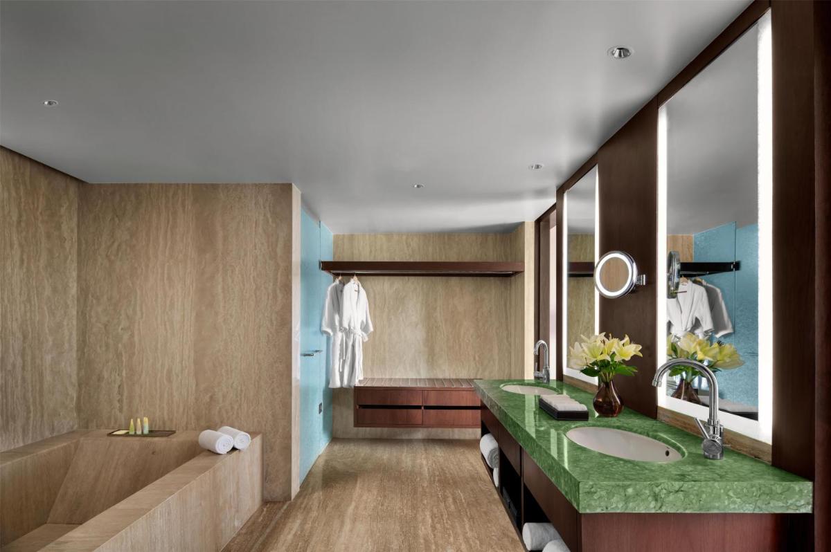 a bathroom with two sinks and a large mirror at Park Hyatt Chennai in Chennai