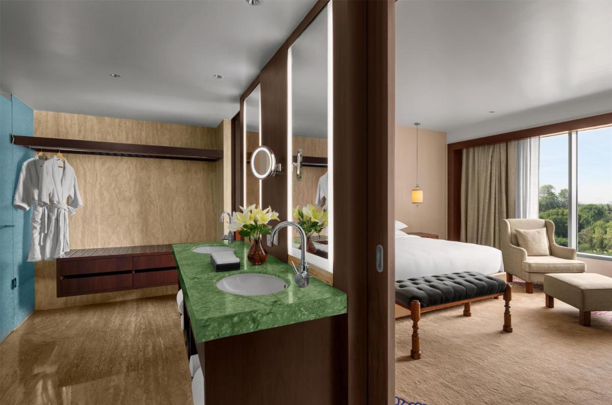 a hotel room with a bed and a bathroom at Park Hyatt Chennai in Chennai