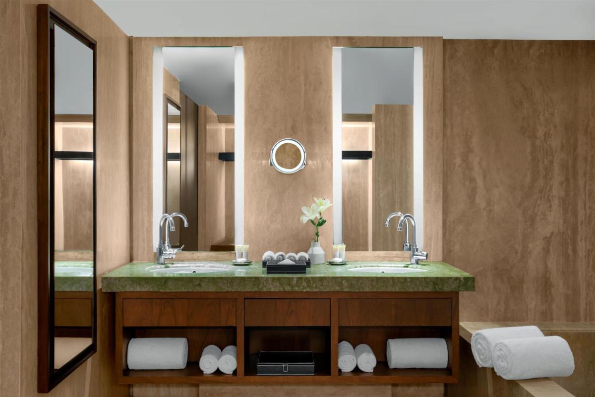 a bathroom with a sink and two mirrors at Park Hyatt Chennai in Chennai