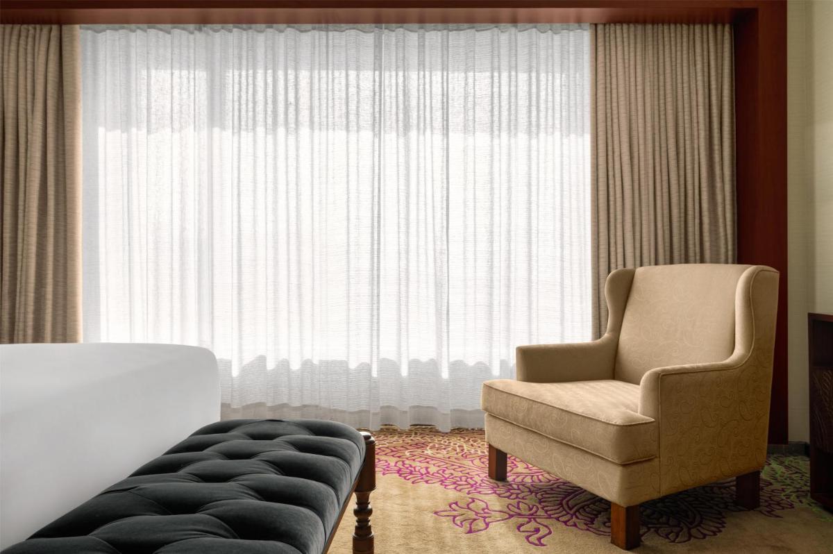 a living room with a chair and a window at Park Hyatt Chennai in Chennai