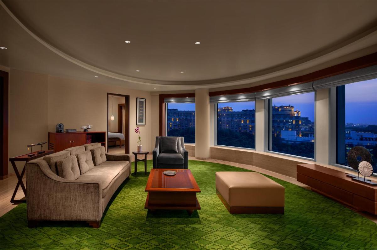 a living room with a couch and chairs and windows at Park Hyatt Chennai in Chennai