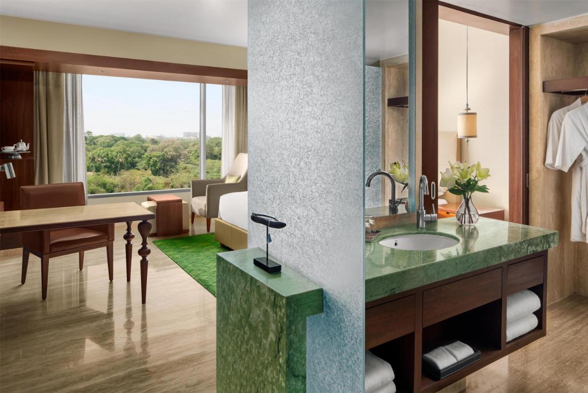 a bathroom with a sink and a room with a desk at Park Hyatt Chennai in Chennai