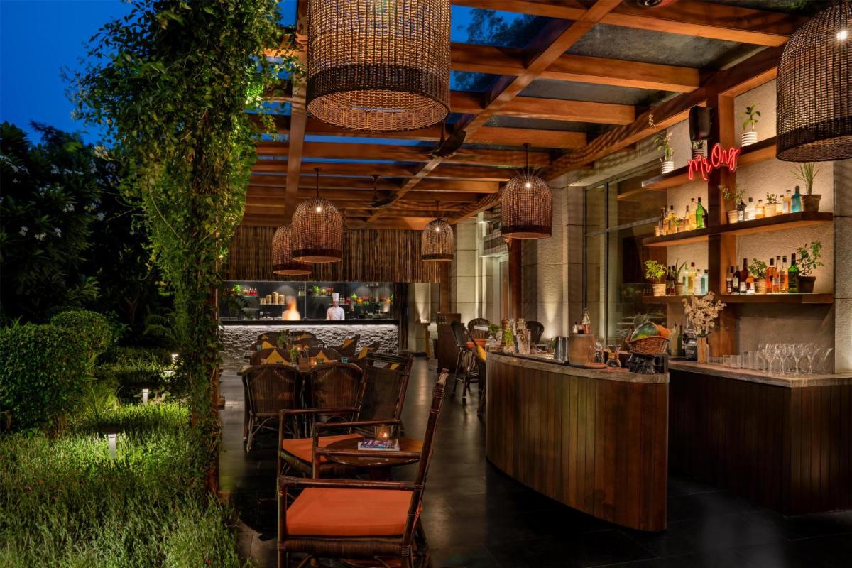 a restaurant with a bar with people sitting at tables at Park Hyatt Chennai in Chennai