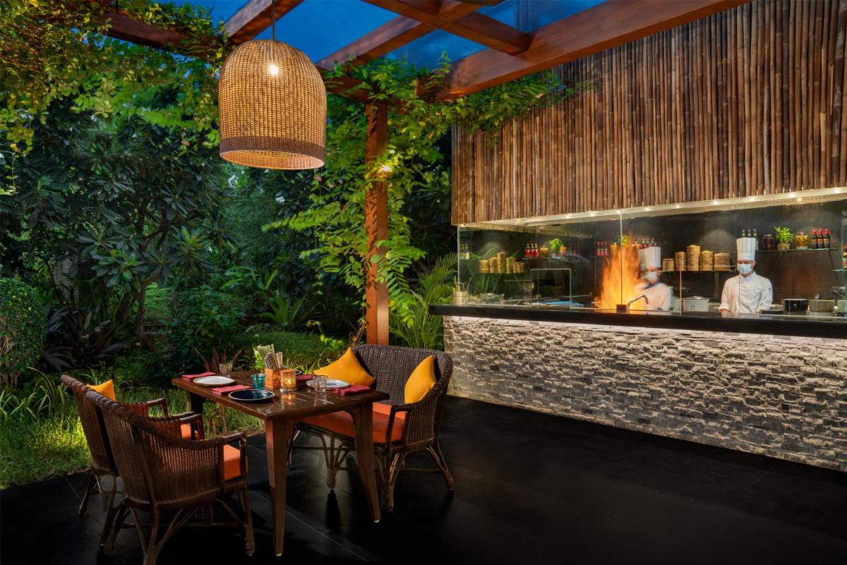 a restaurant with a table and chairs and a bar at Park Hyatt Chennai in Chennai