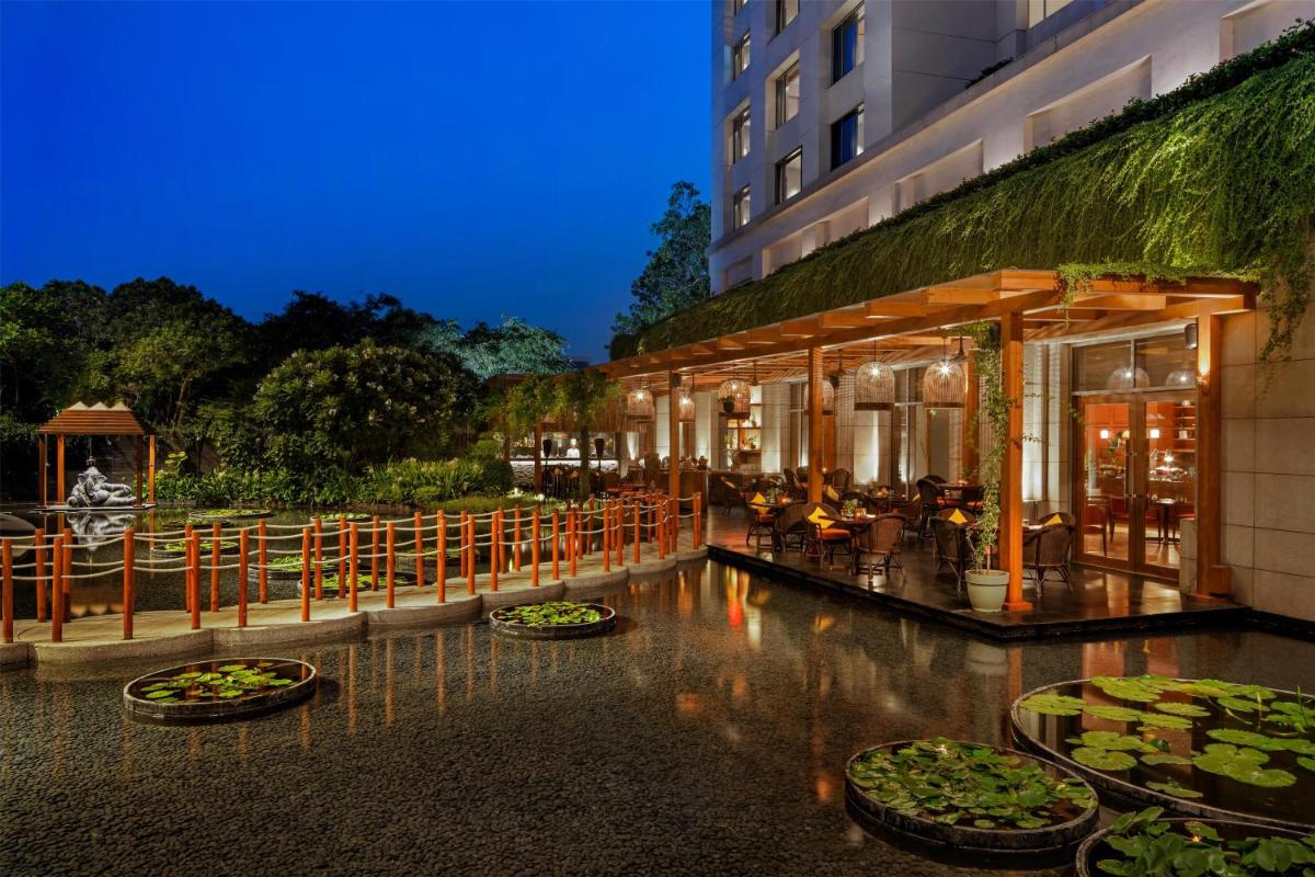 a hotel with tables and chairs and a building at Park Hyatt Chennai in Chennai