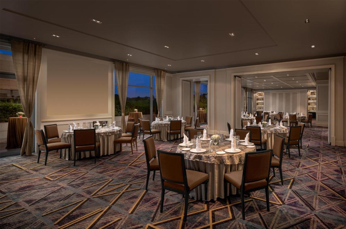 a banquet room with tables and chairs and a screen at Park Hyatt Chennai in Chennai