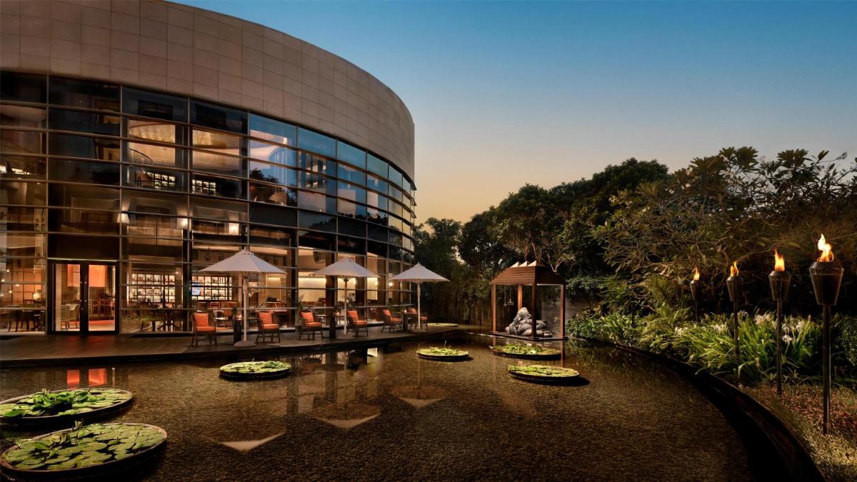 a large building with a pond in front of it at Park Hyatt Chennai in Chennai