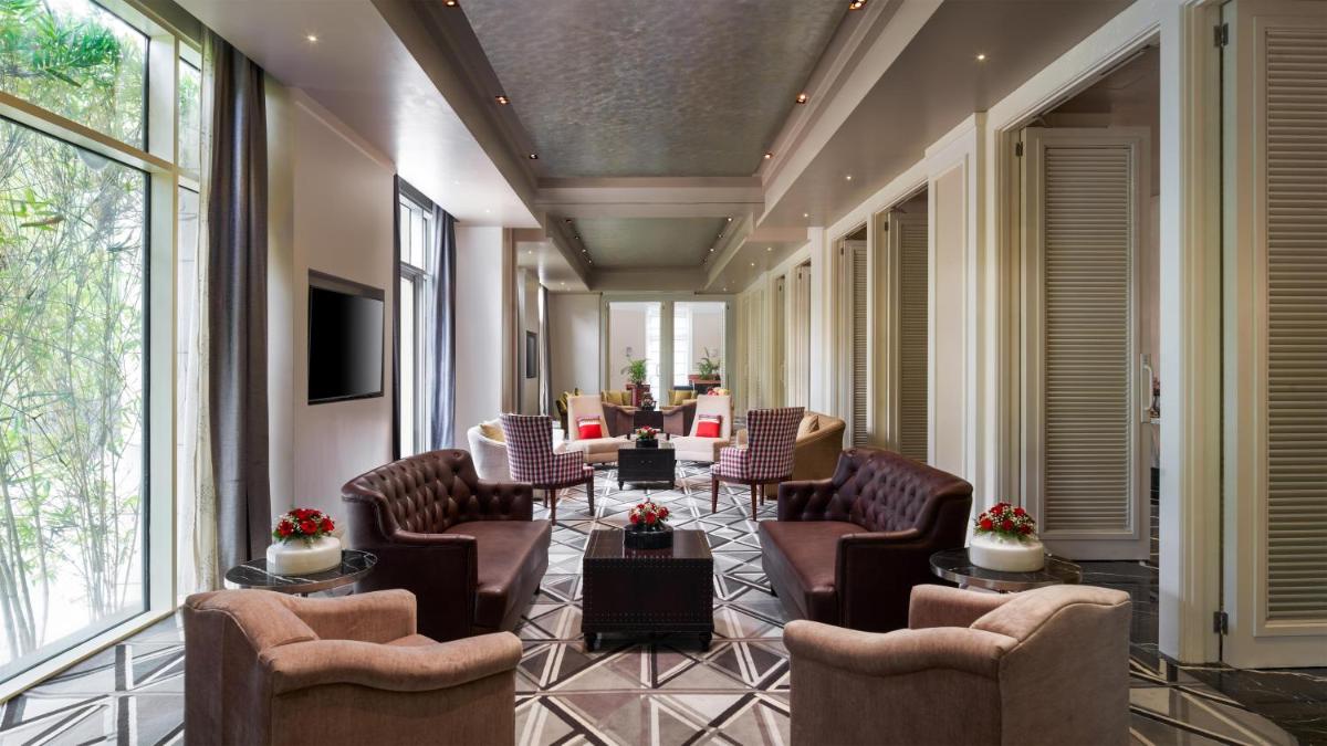 a waiting room with chairs and tables and windows at Park Hyatt Chennai in Chennai