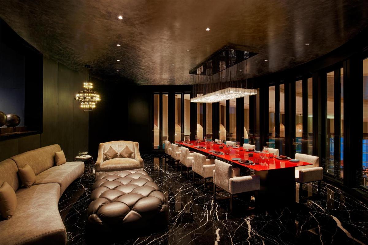 a dining room with a long table and leather chairs at Park Hyatt Chennai in Chennai