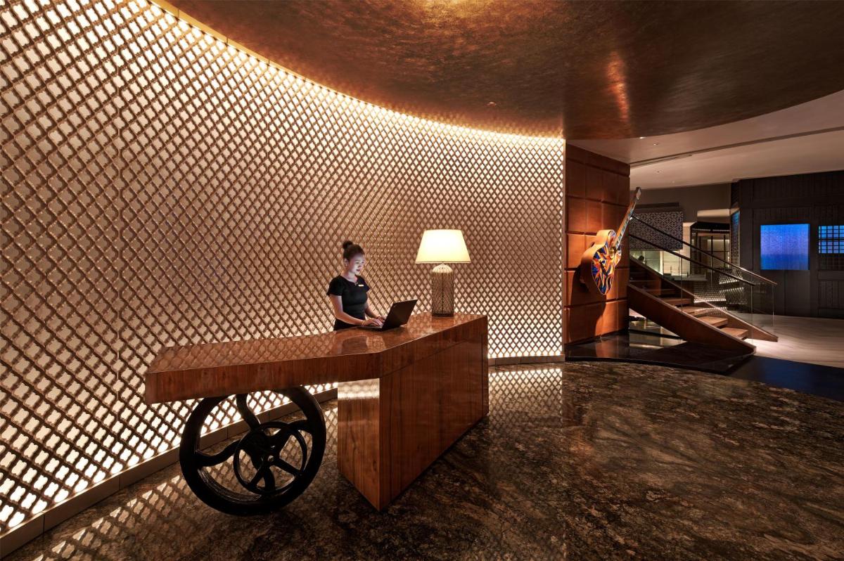 a woman sitting at a desk in a room with a laptop at Park Hyatt Chennai in Chennai