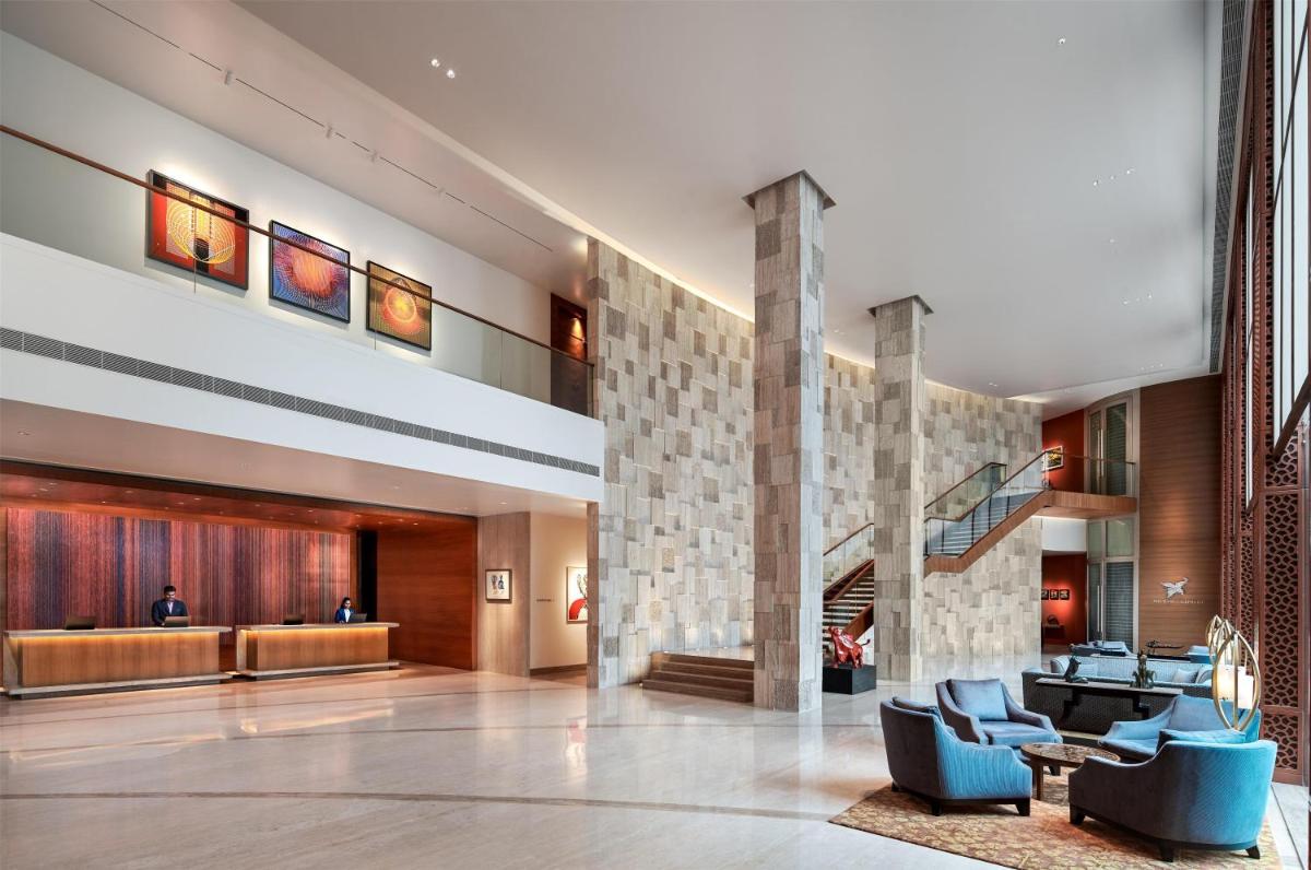 a lobby of a hotel with blue chairs at Park Hyatt Chennai in Chennai