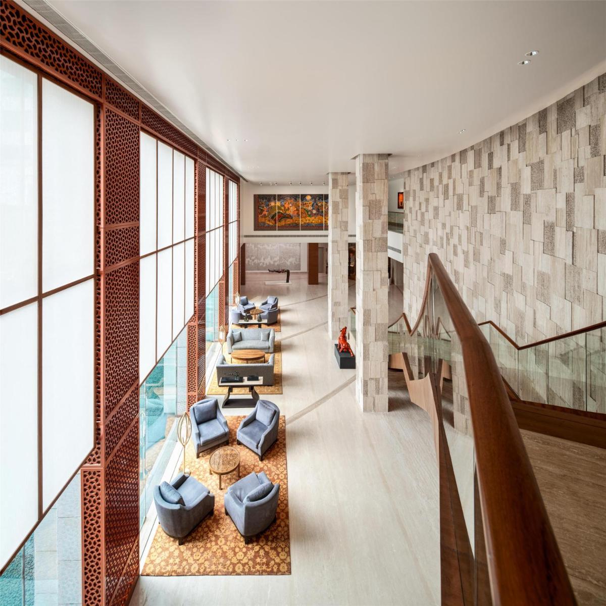 a lobby with couches and chairs in a building at Park Hyatt Chennai in Chennai