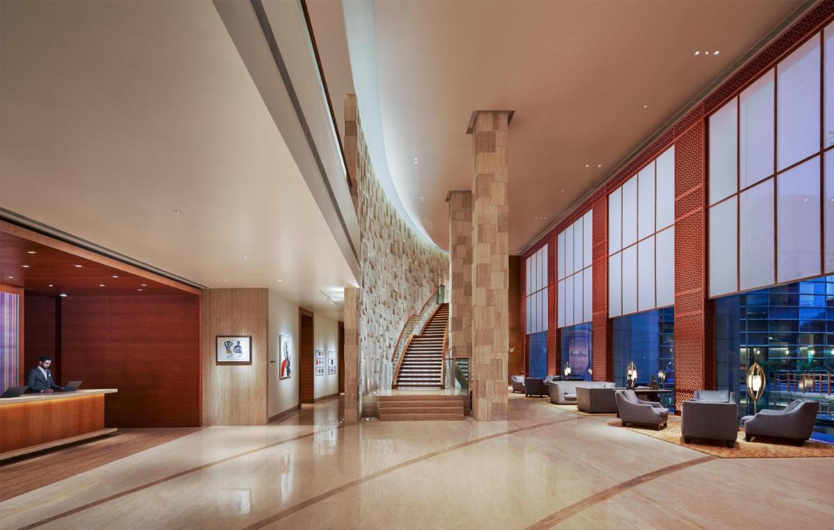 a lobby of a building with chairs and windows at Park Hyatt Chennai in Chennai