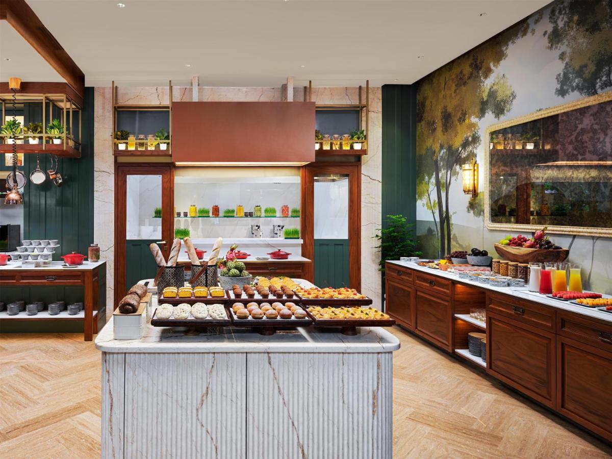 a buffet line with food on a counter in a restaurant at Park Hyatt Chennai in Chennai