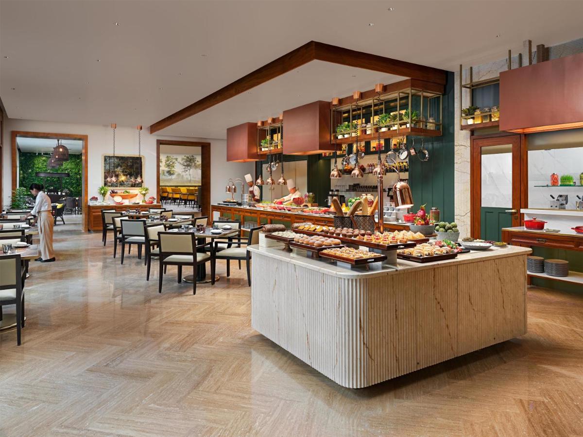 a restaurant with a counter with food on it at Park Hyatt Chennai in Chennai
