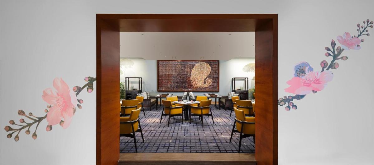 a dining room with a table and yellow chairs at Park Hyatt Chennai in Chennai
