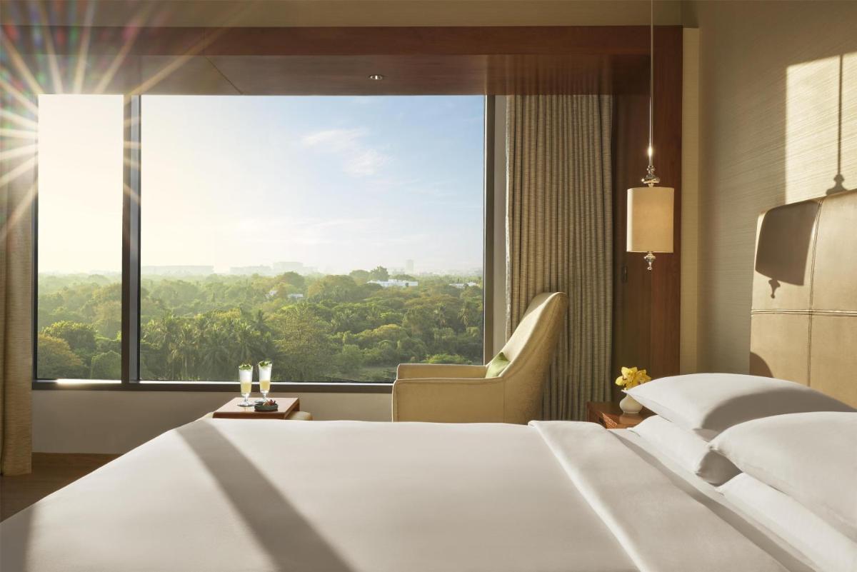 a hotel room with a bed and a large window at Park Hyatt Chennai in Chennai