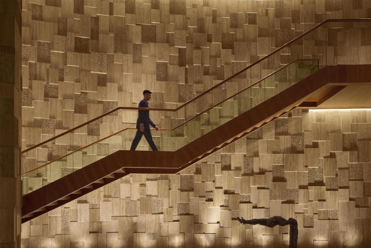 a man walking down the stairs in a building at Park Hyatt Chennai in Chennai