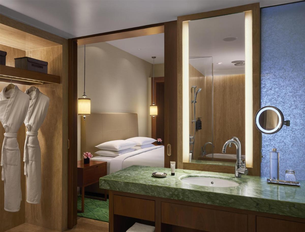 a hotel bathroom with a sink and a bed at Park Hyatt Chennai in Chennai