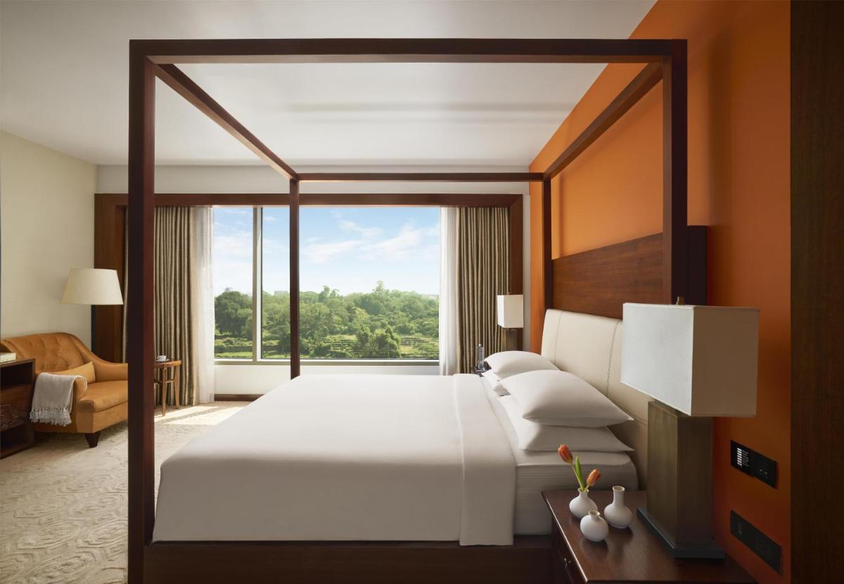 a bedroom with a large bed and a large window at Park Hyatt Chennai in Chennai