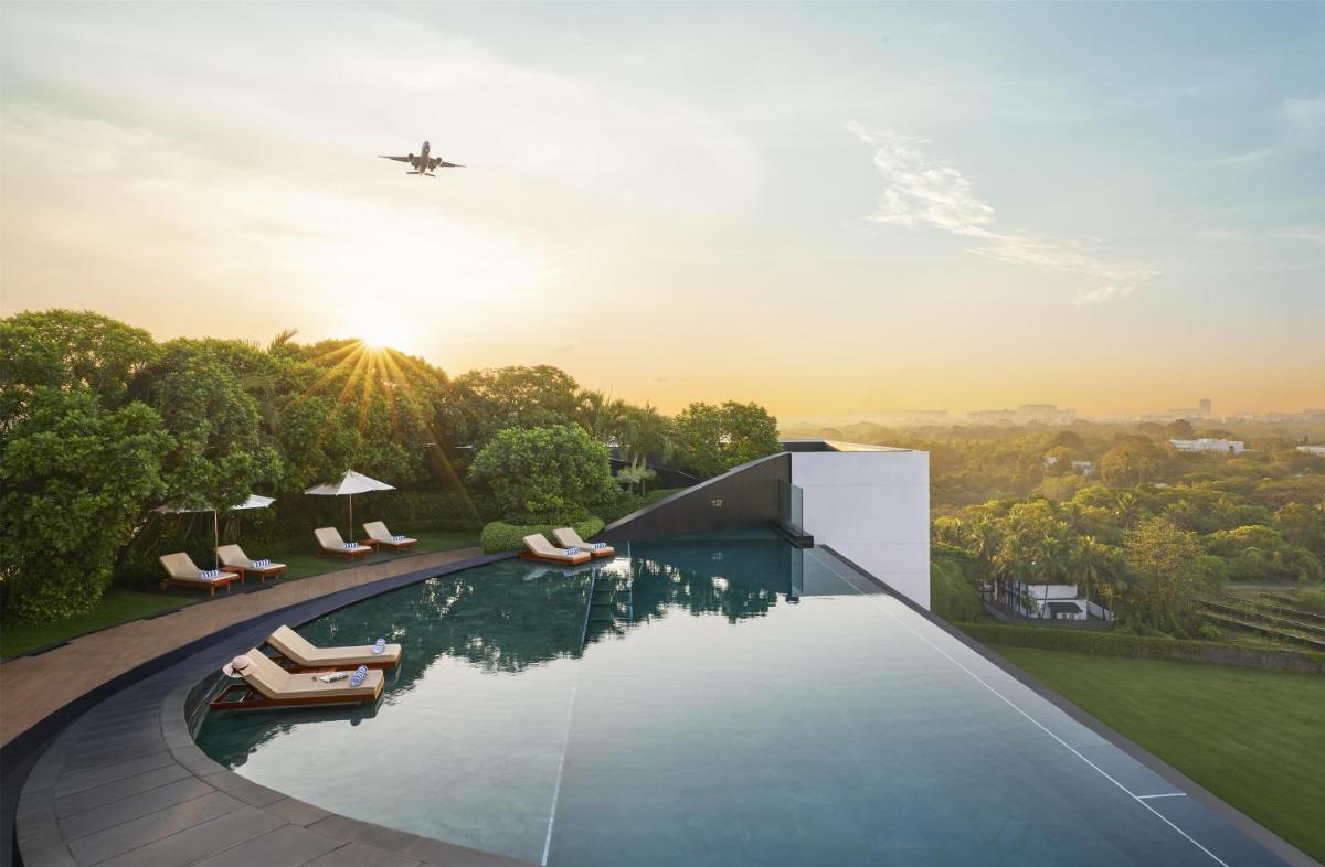 an airplane flying over a swimming pool with a plane at Park Hyatt Chennai in Chennai