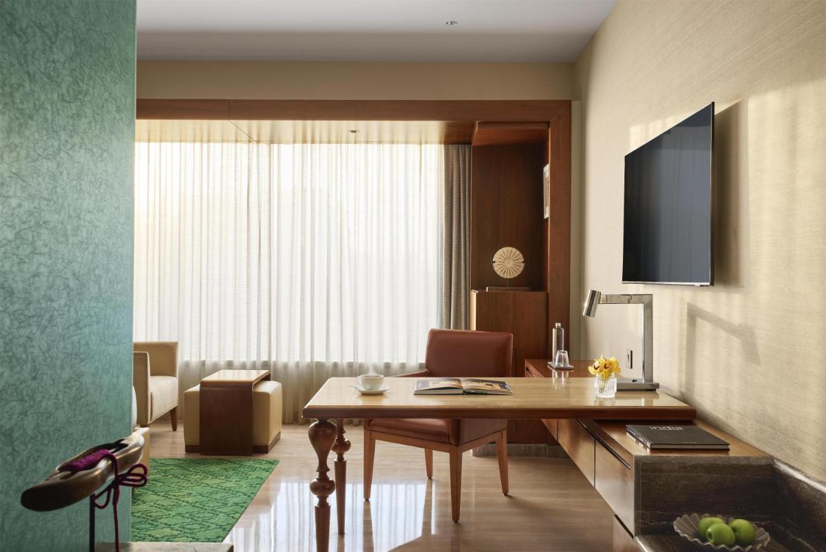 a living room with a desk and a table and a room at Park Hyatt Chennai in Chennai
