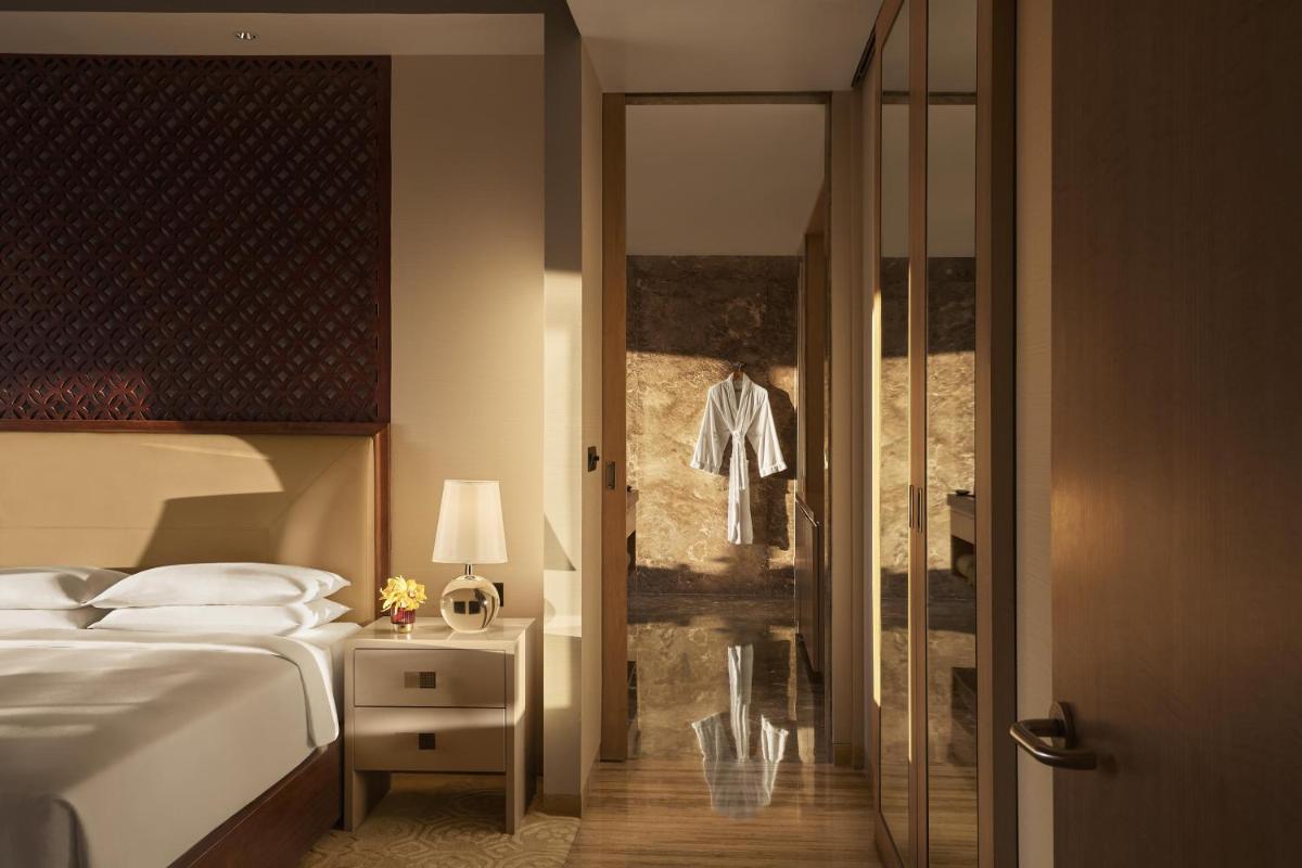 a bedroom with a bed and a walk in shower at Park Hyatt Chennai in Chennai