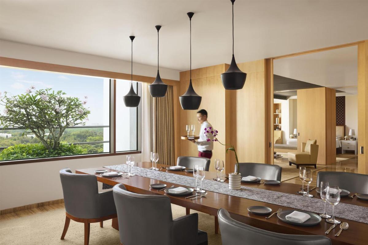 a dining room with a long table and chairs at Park Hyatt Chennai in Chennai