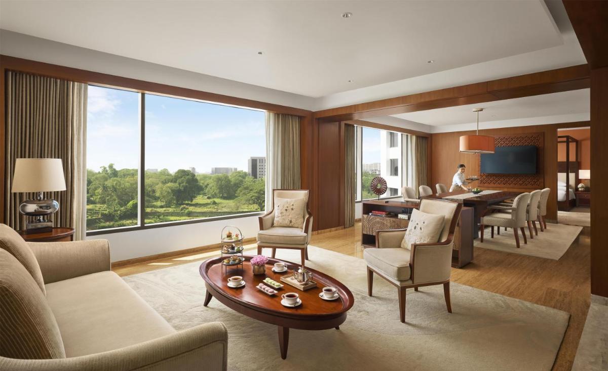 a living room with a table and a dining room at Park Hyatt Chennai in Chennai