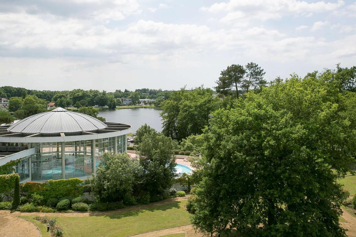 vue aérienne d'un bâtiment et d'un lac dans l'établissement Best Western Hotel Sourcéo, à Saint-Paul-lès-Dax