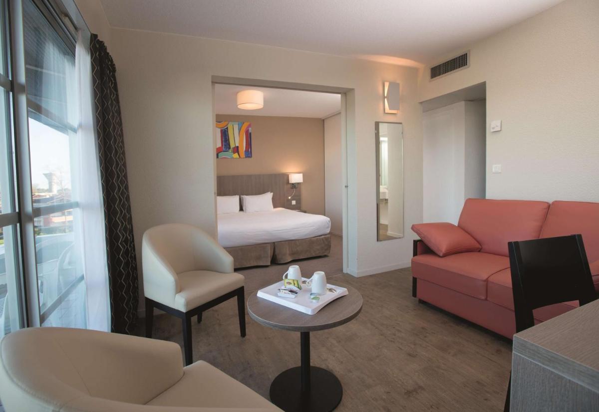 une chambre d'hôtel avec un lit, un canapé et une table dans l'établissement Best Western Hotel Sourcéo, à Saint-Paul-lès-Dax