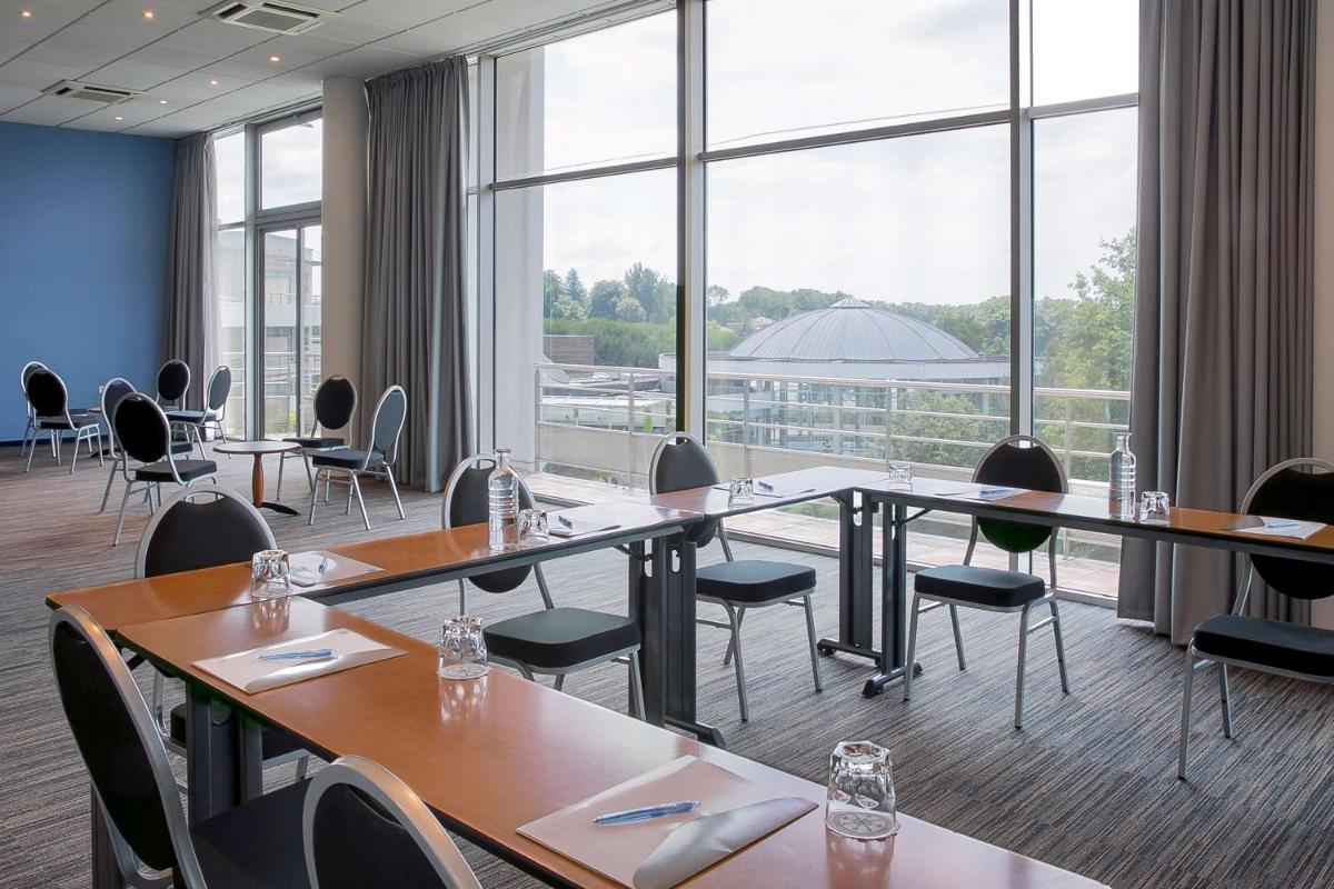 une salle de conférence avec des tables et des chaises et de grandes fenêtres dans l'établissement Best Western Hotel Sourcéo, à Saint-Paul-lès-Dax 71 autres photos