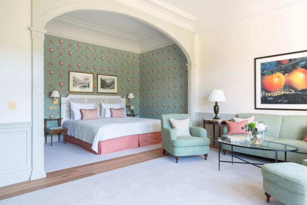 ein Schlafzimmer mit einem Bett, einer Couch und einem Tisch in der Unterkunft Brenners Park Hotel & Spa, Oetker Hotels in Baden-Baden