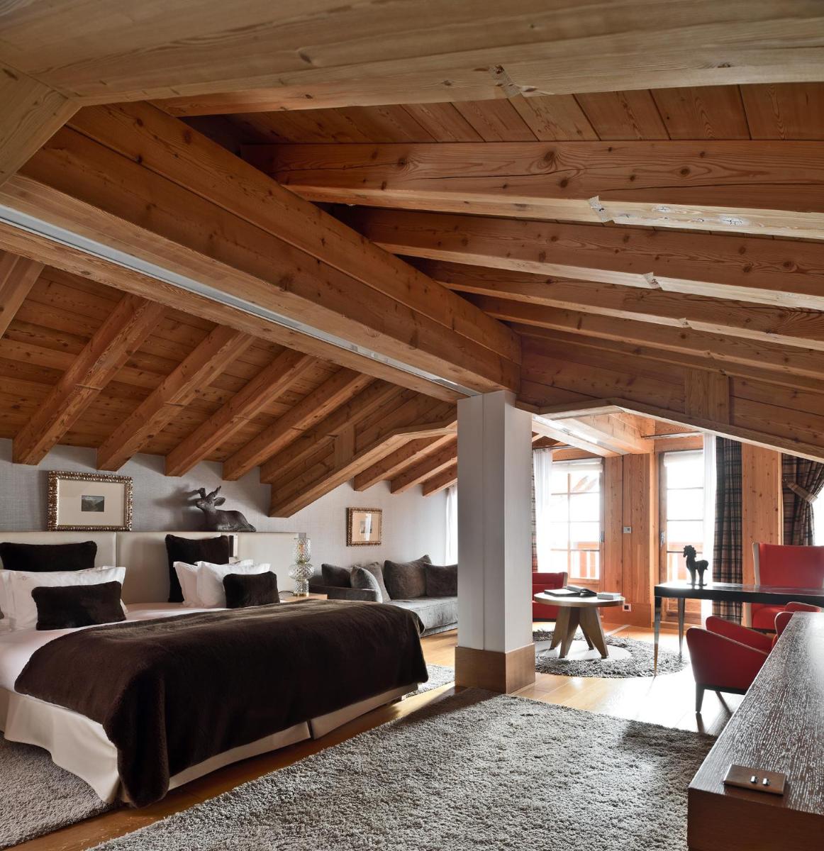une chambre avec un grand lit et des plafonds en bois dans l'établissement Le Strato, à Courchevel une chambre avec un grand lit et des plafonds en bois dans l'établissement Le Strato, à Courchevel