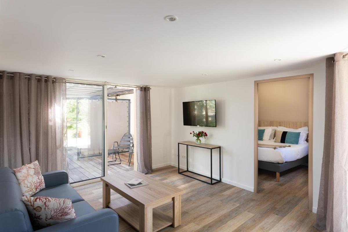 un salon avec un canapé et un lit dans l'établissement Golfe Hôtel & Spa Porto-Vecchio, à Porto-Vecchio