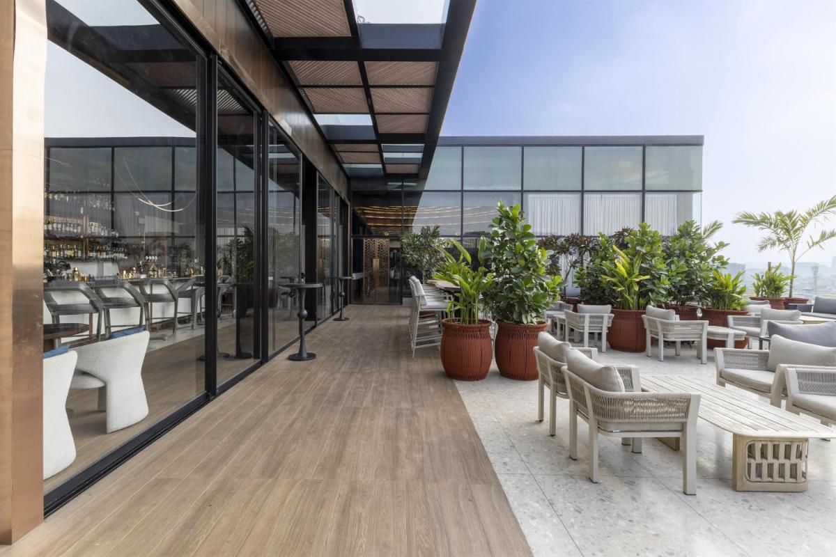 a rendering of a restaurant with tables and chairs at Radisson Blu Hotel Pune Kharadi in Pune
